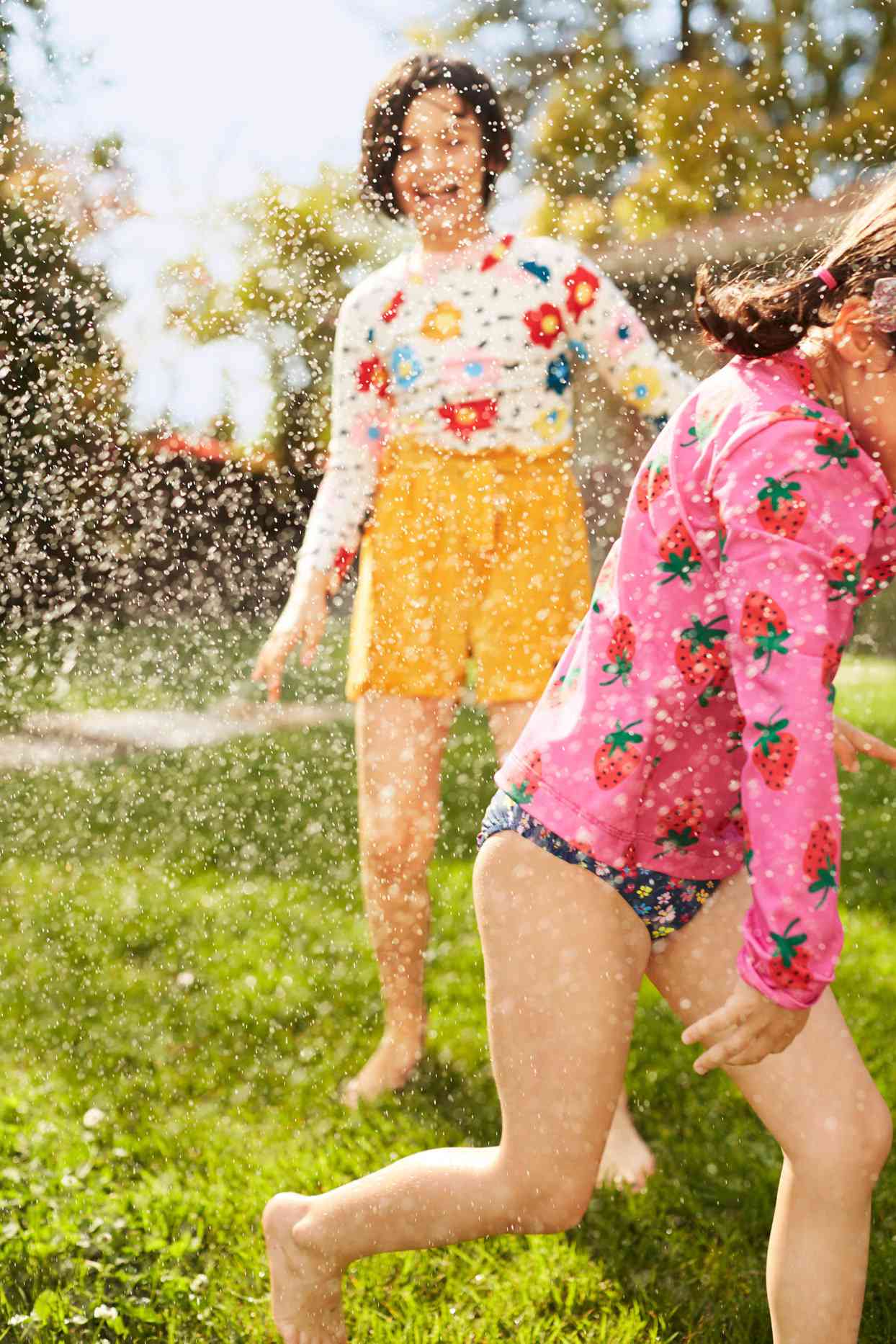 girls playing sprinkler