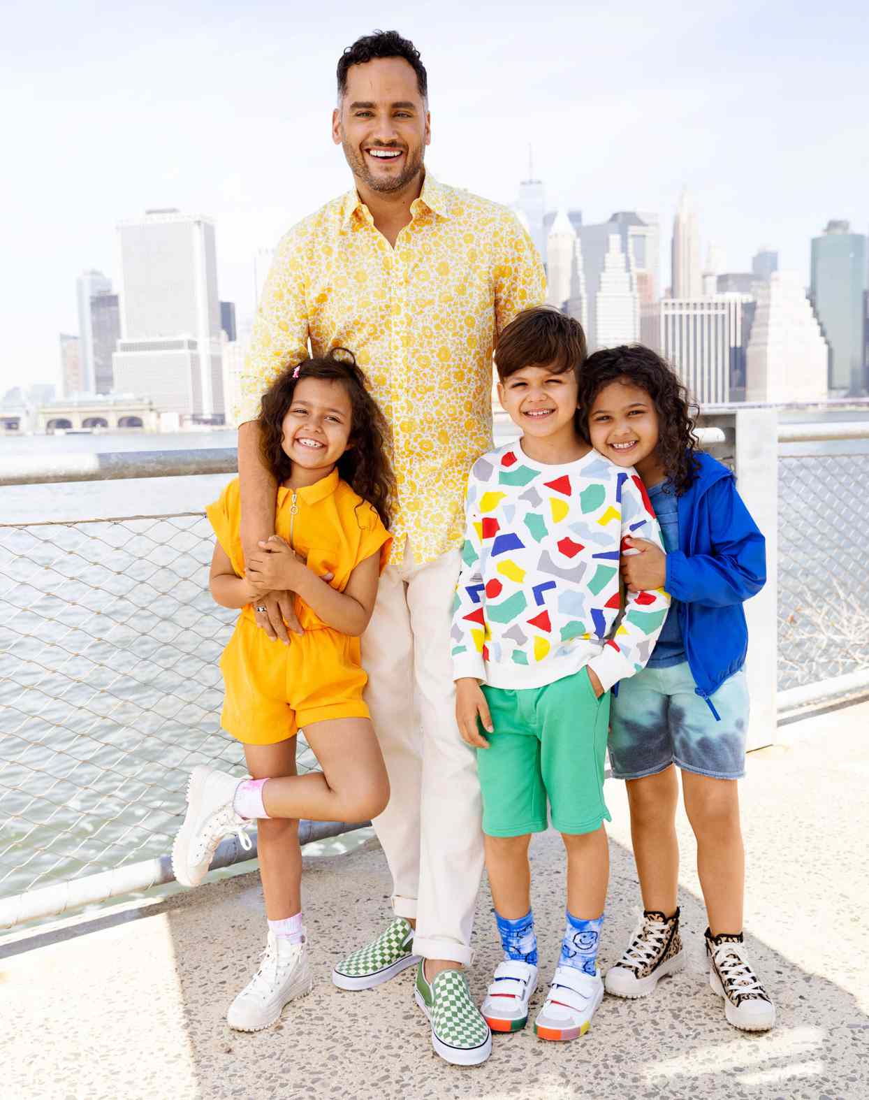 José Rolón with three kids portrait in front of NYC skyline