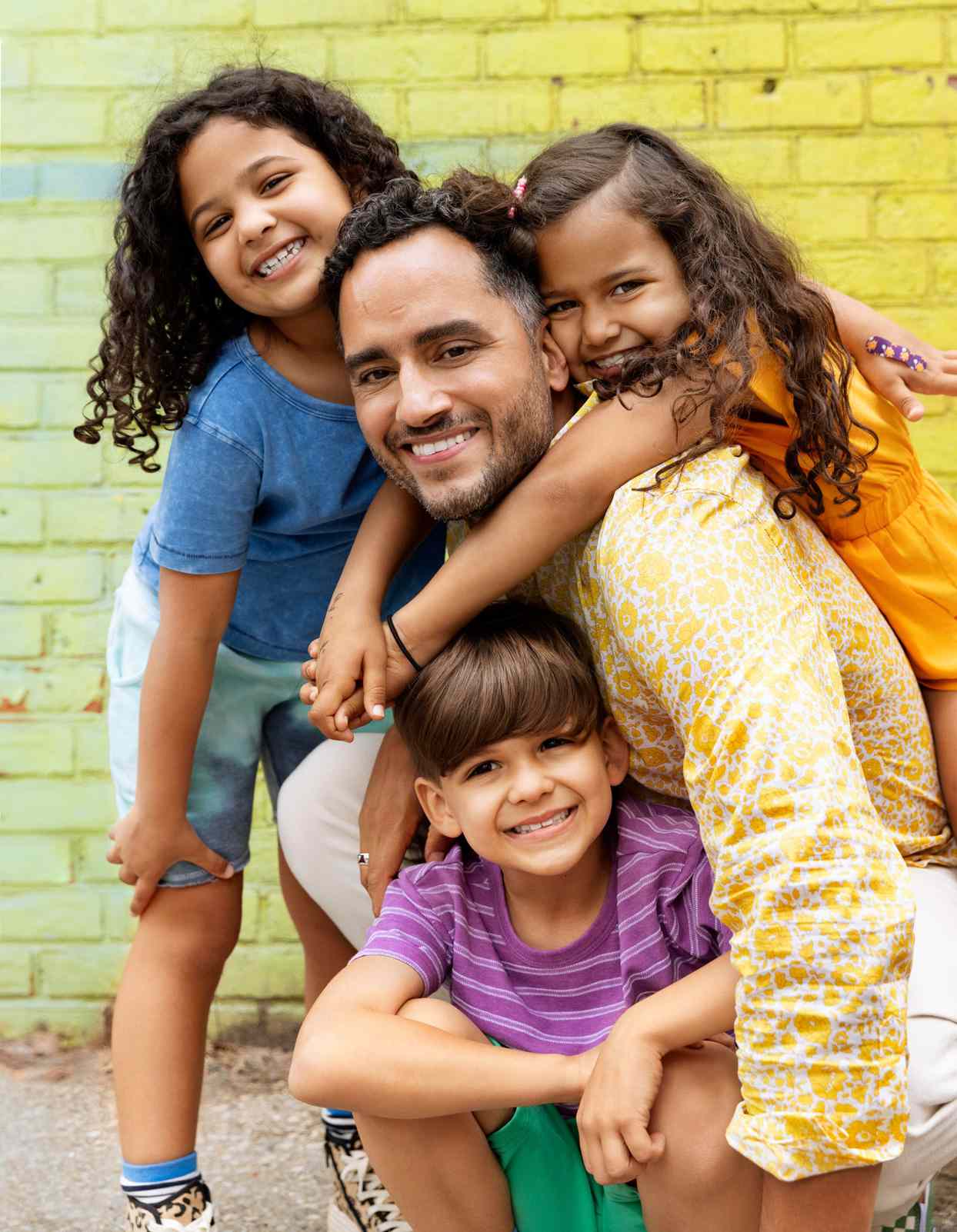 Jose with three kids in colorful outfits