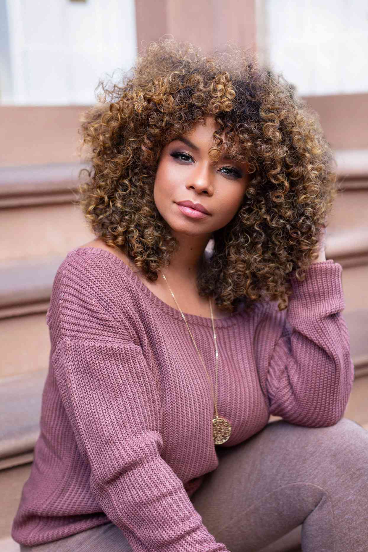 woman in purple sweater with curly hair
