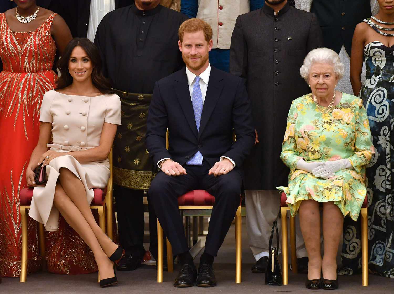 An image of a Meghan Markle, Prince Harry, and Queen Elizabeth II.