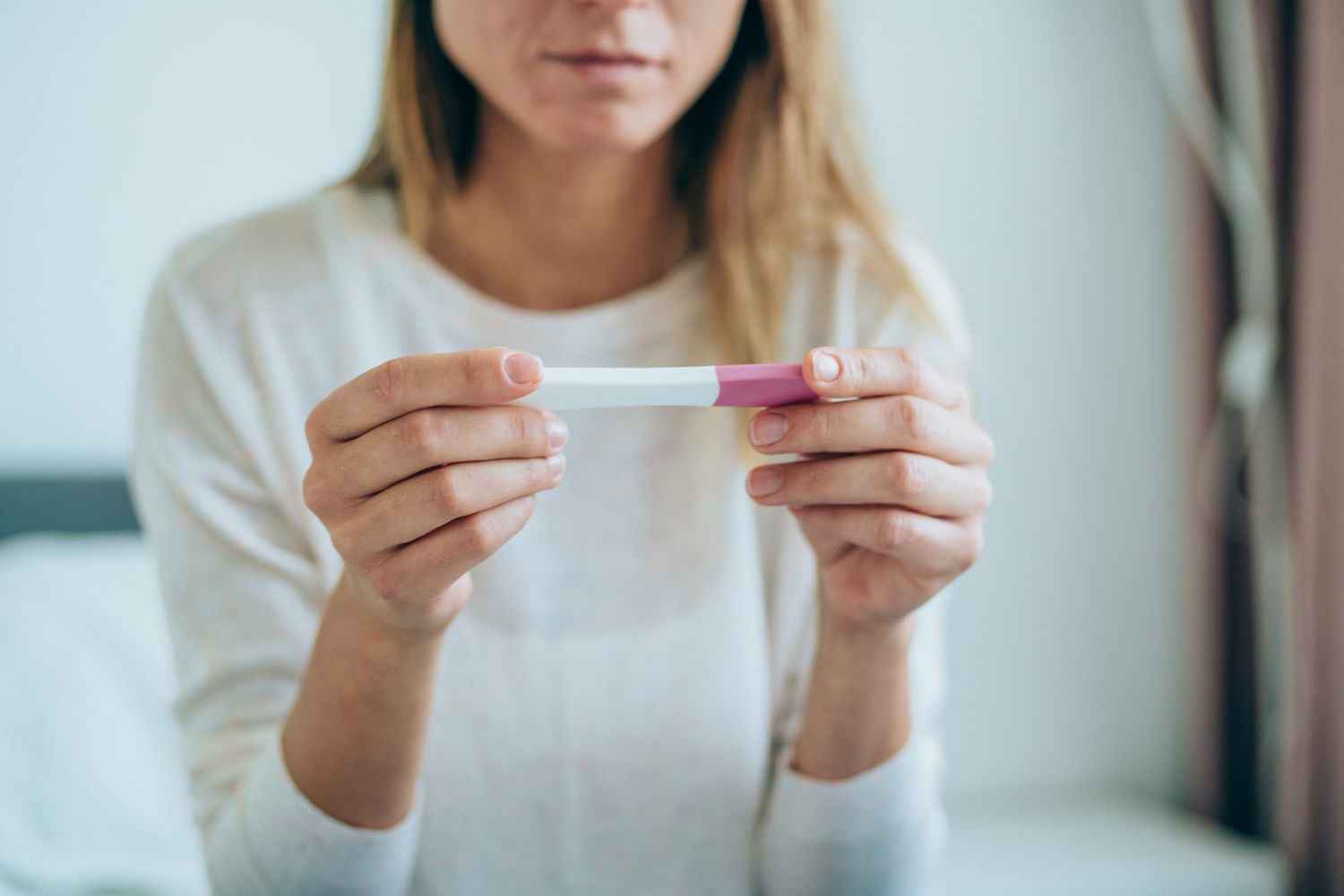 An image of a woman with a pregnancy test.