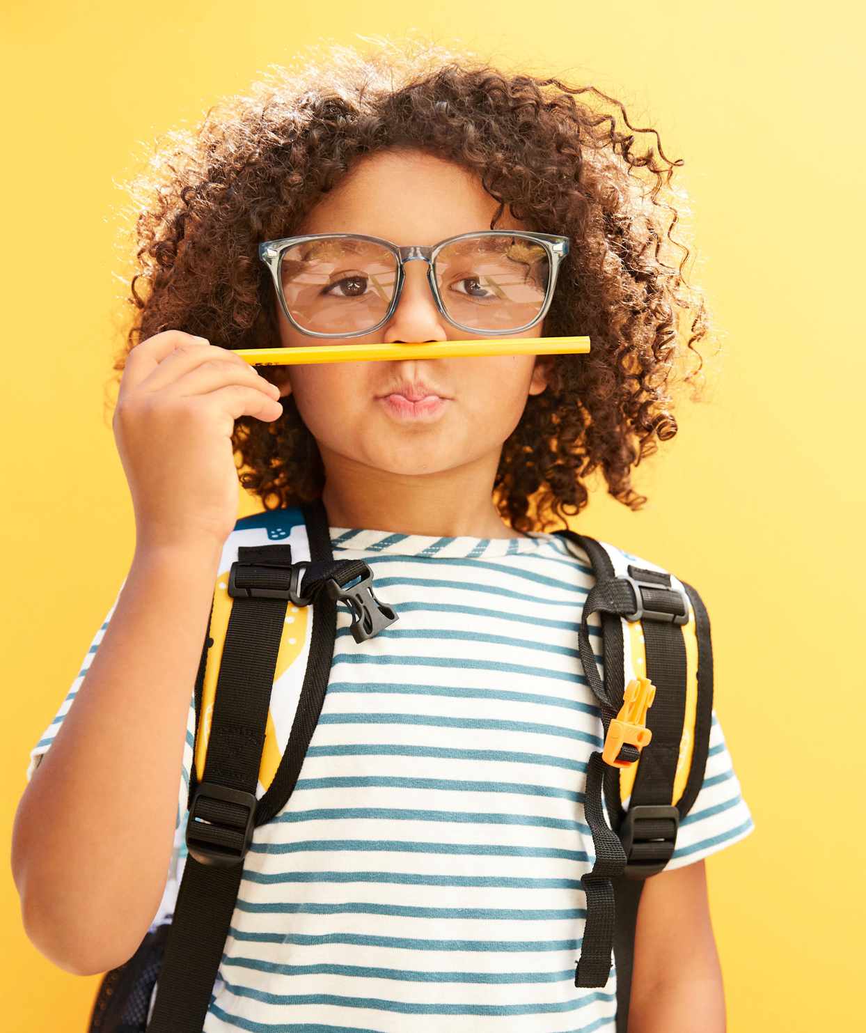 child holding mechanical pencil up to nose