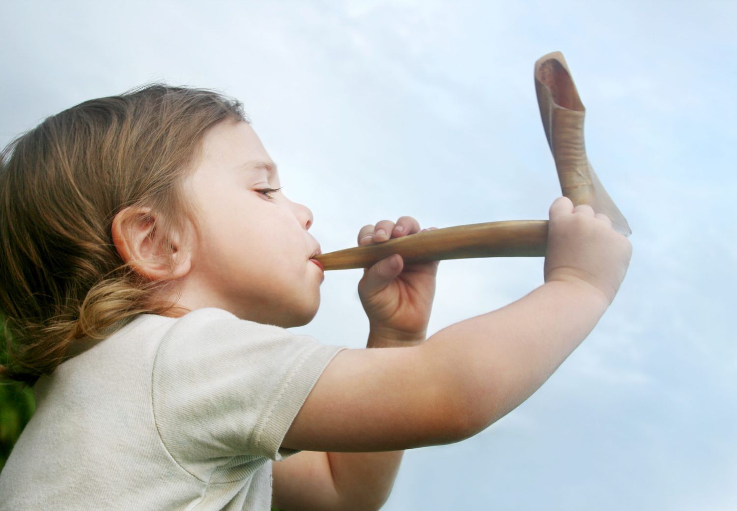 An image of a child blowing a shofar.