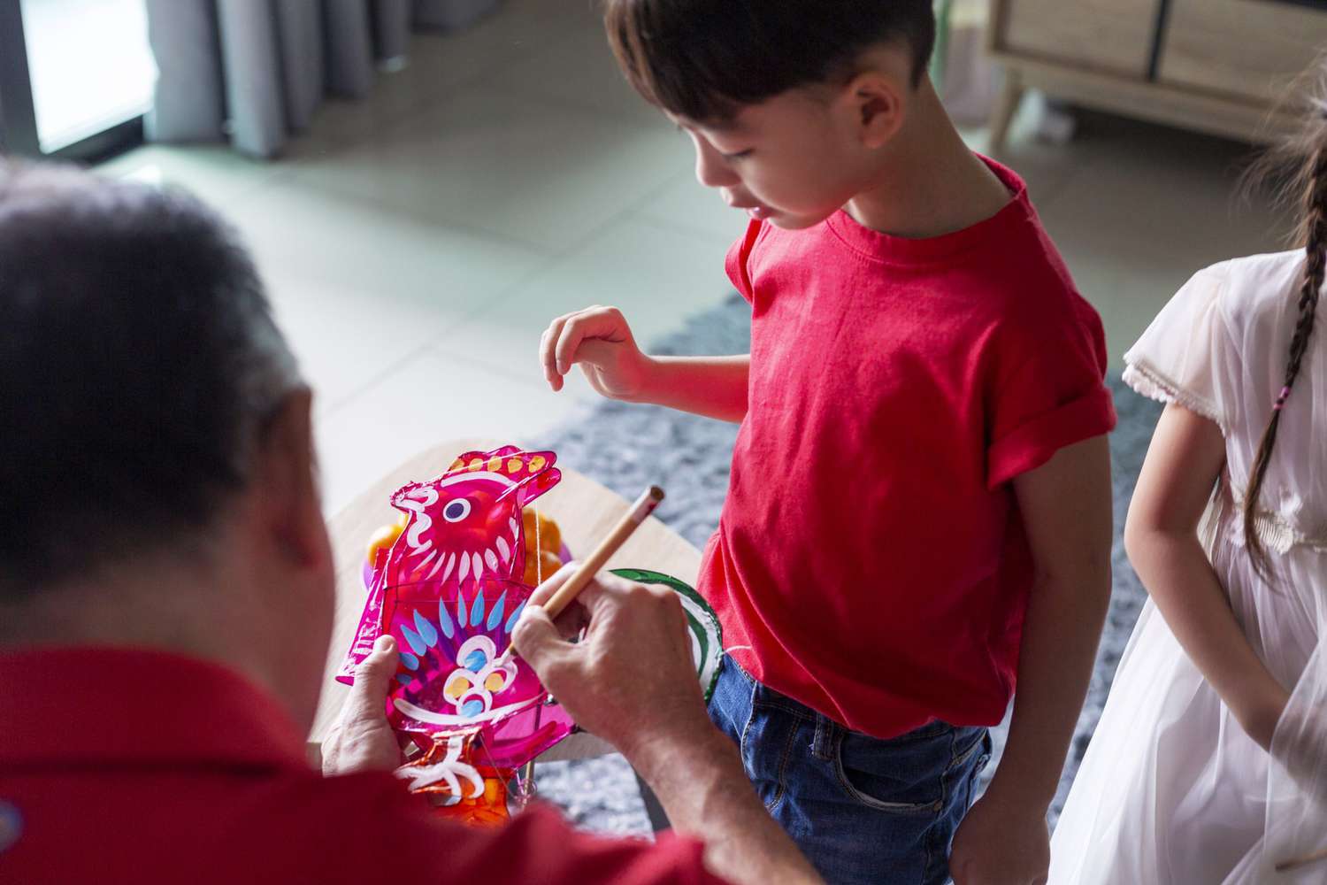 An image of a child and their grandparent painting a lantern.