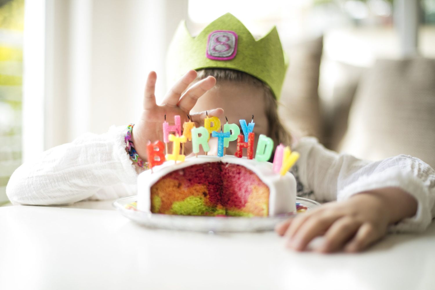 An image of a child behind a birthday cake.