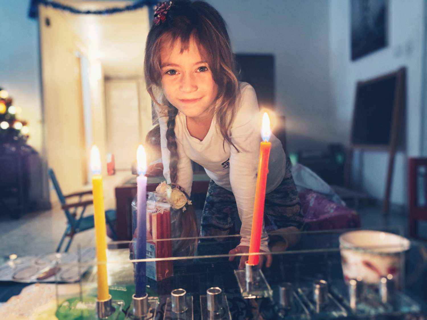 An image of a little girl lighting a menorah.