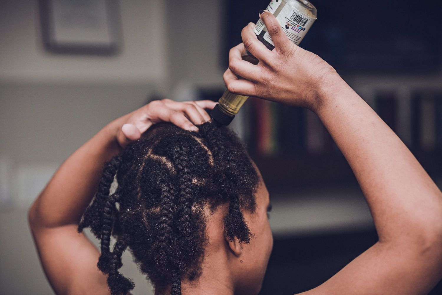 An image of Tomesha's daughter oiling her scalp during their own wash day.