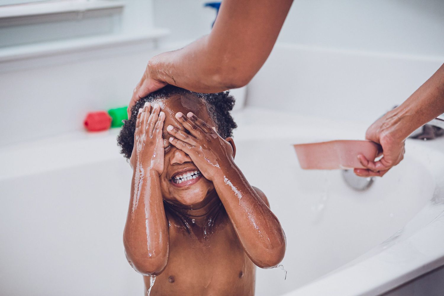 An image of Coleman with his hands over his face getting his hair washed.