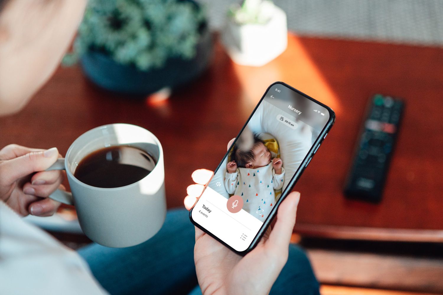 An image of a mother using a baby monitor on her phone.