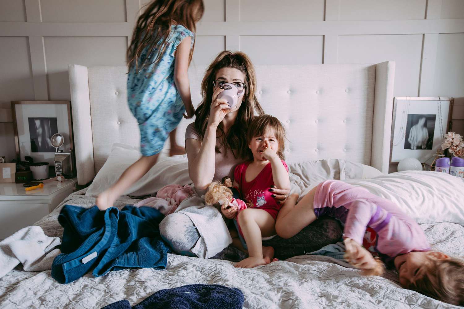 Mom on messy bed with three kids