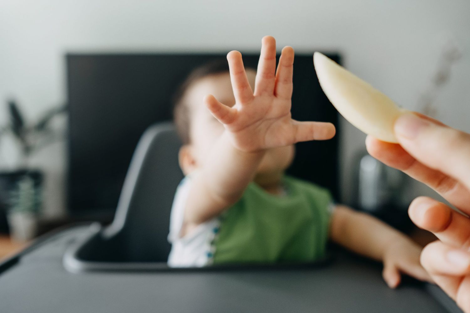 baby reaches for apple with fingers