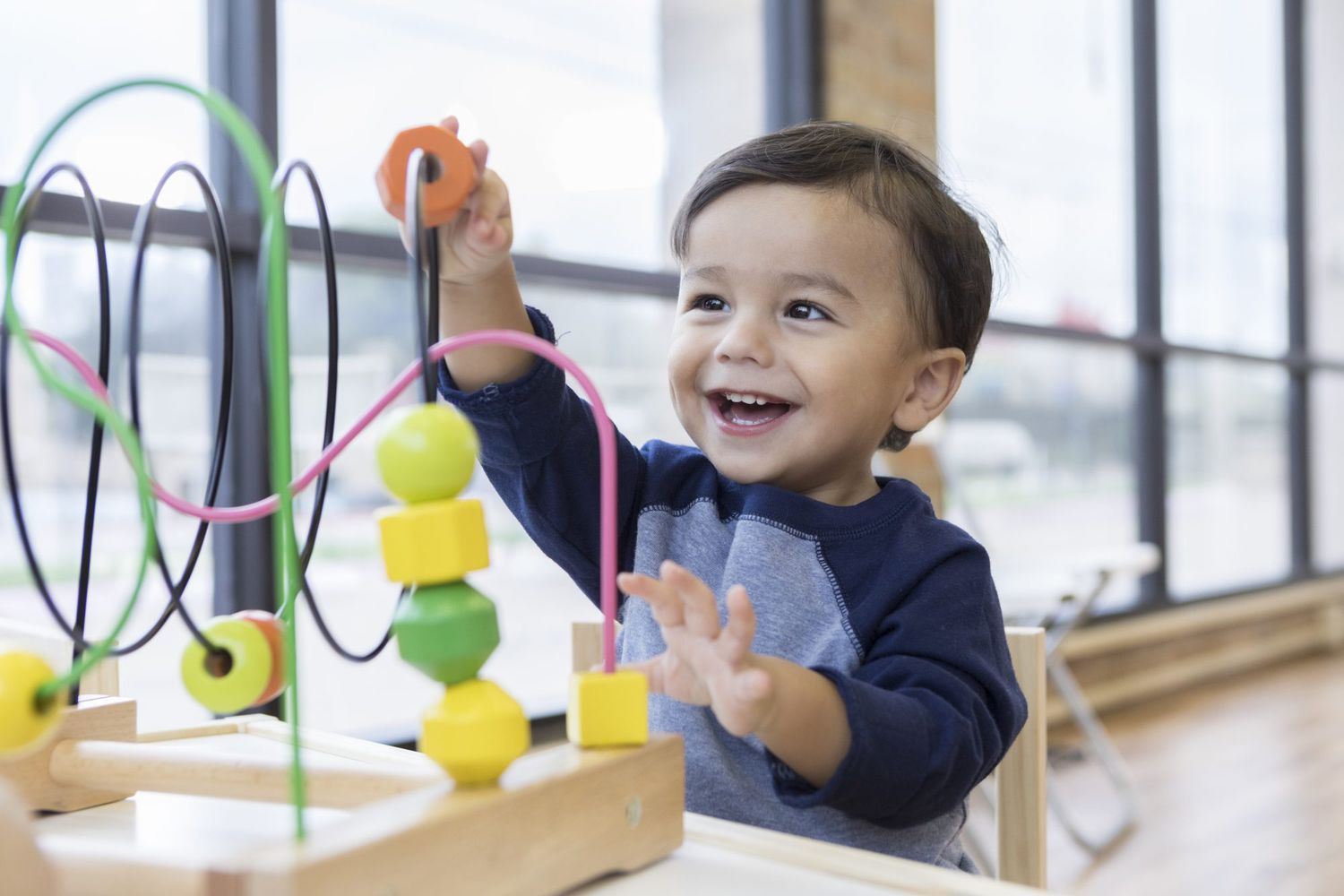 Toddler boy enjoys playing with toys in waiting room