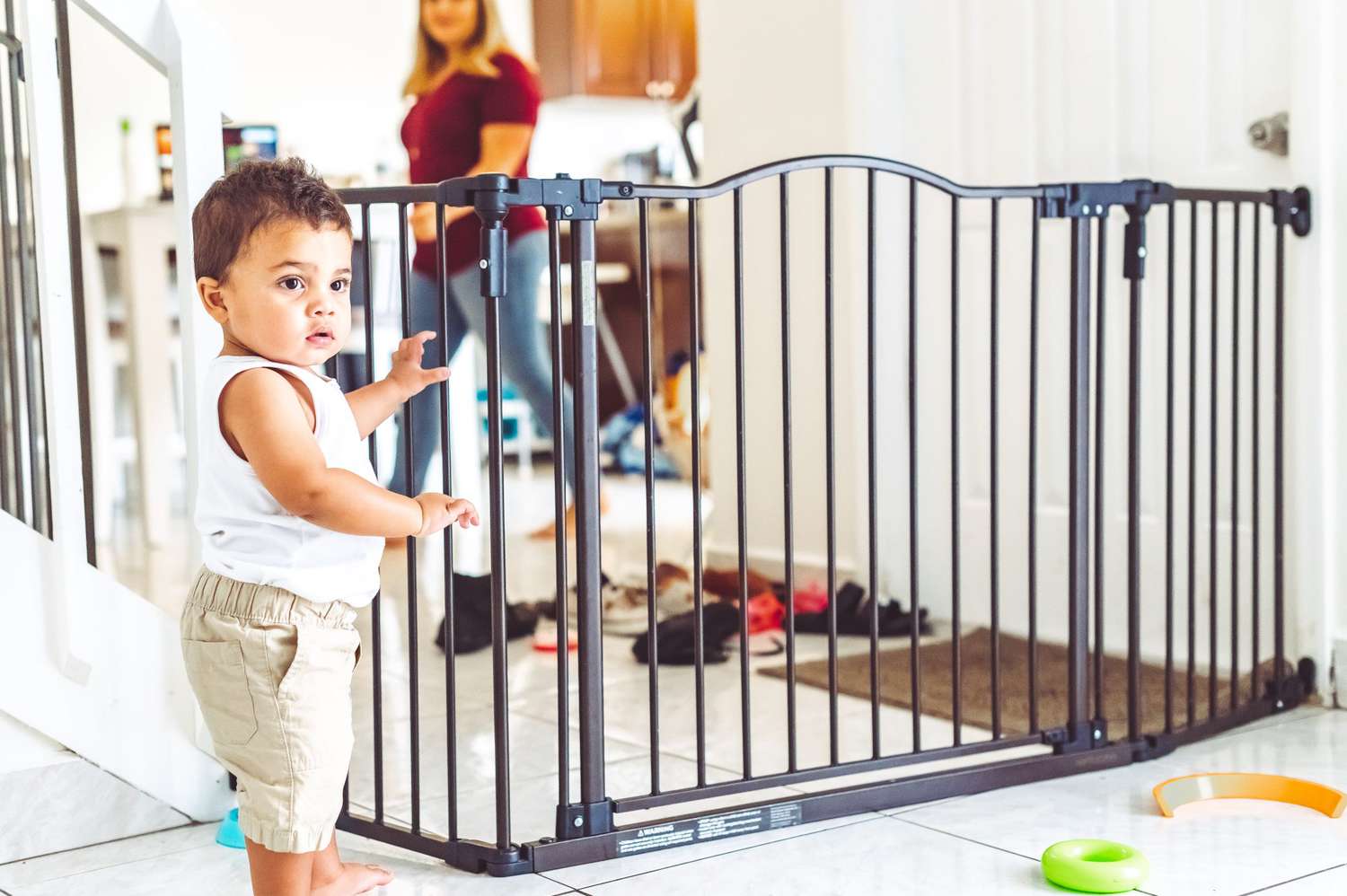 baby standing next to baby gate