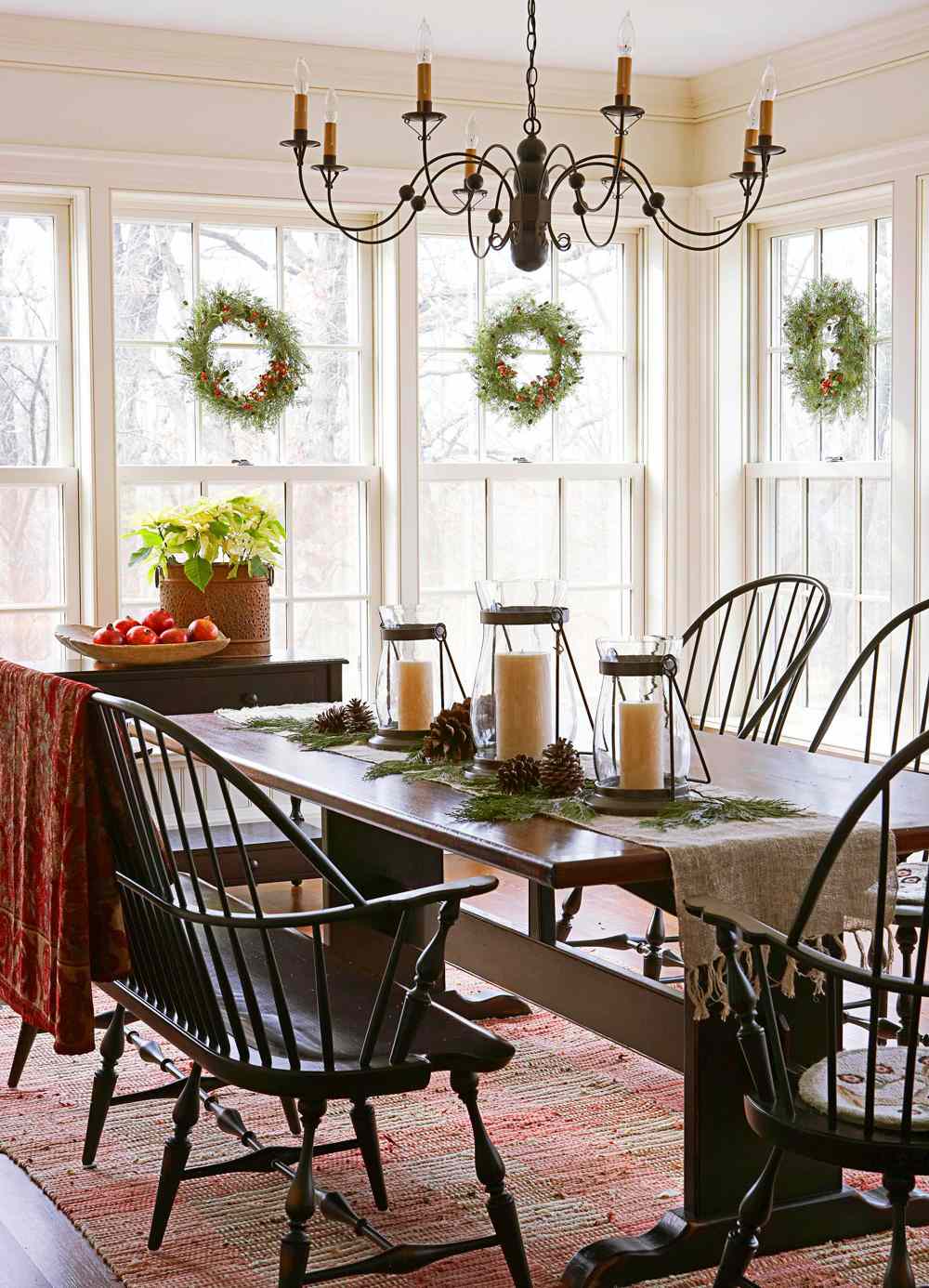 Breakfast room with burlap table runner and three candles on table with pinecones