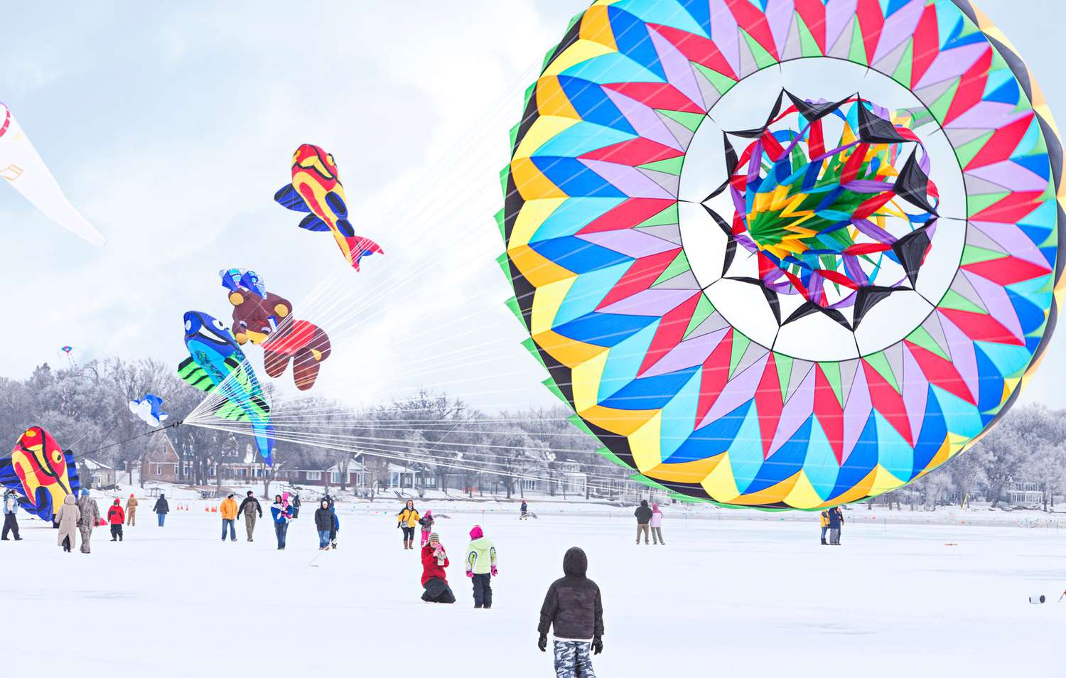 colorful kites above frozen lake