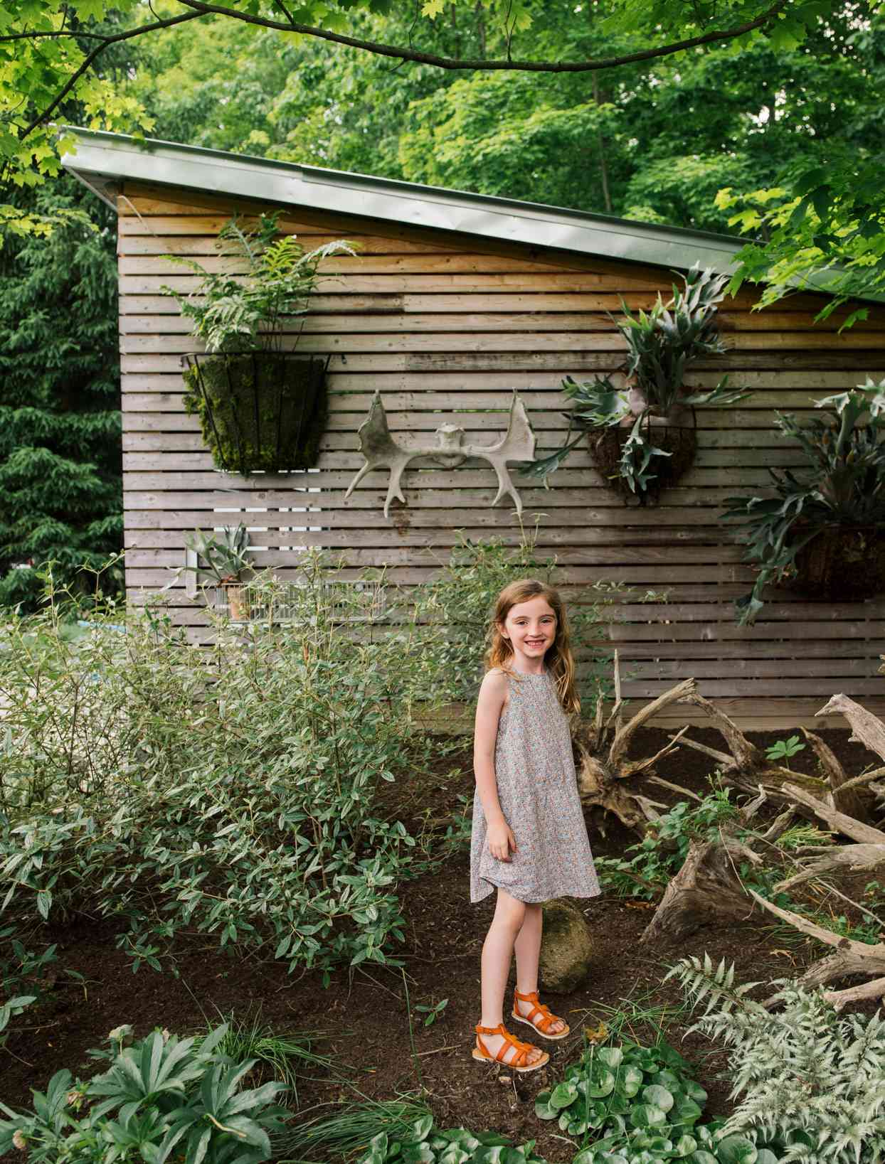 charlotte standing in front of garage wall with staghorn ferns