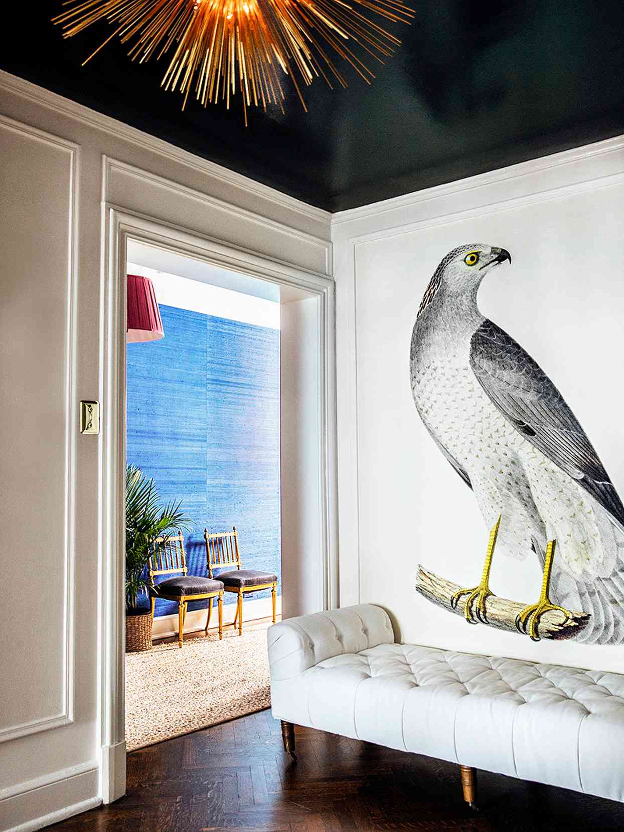large osprey bird mural black ceiling white walls settee gold light fixture