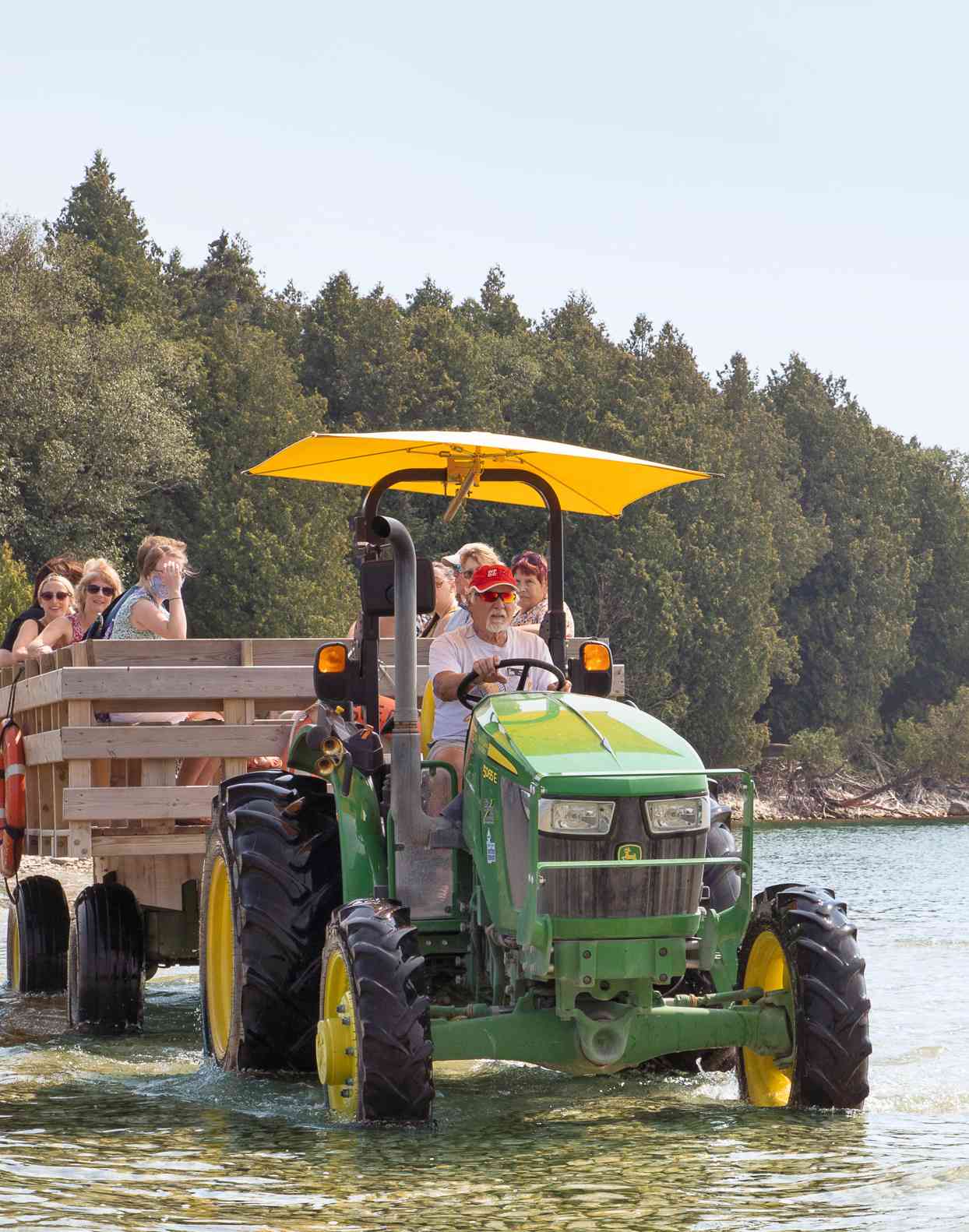 people riding in water on tractor