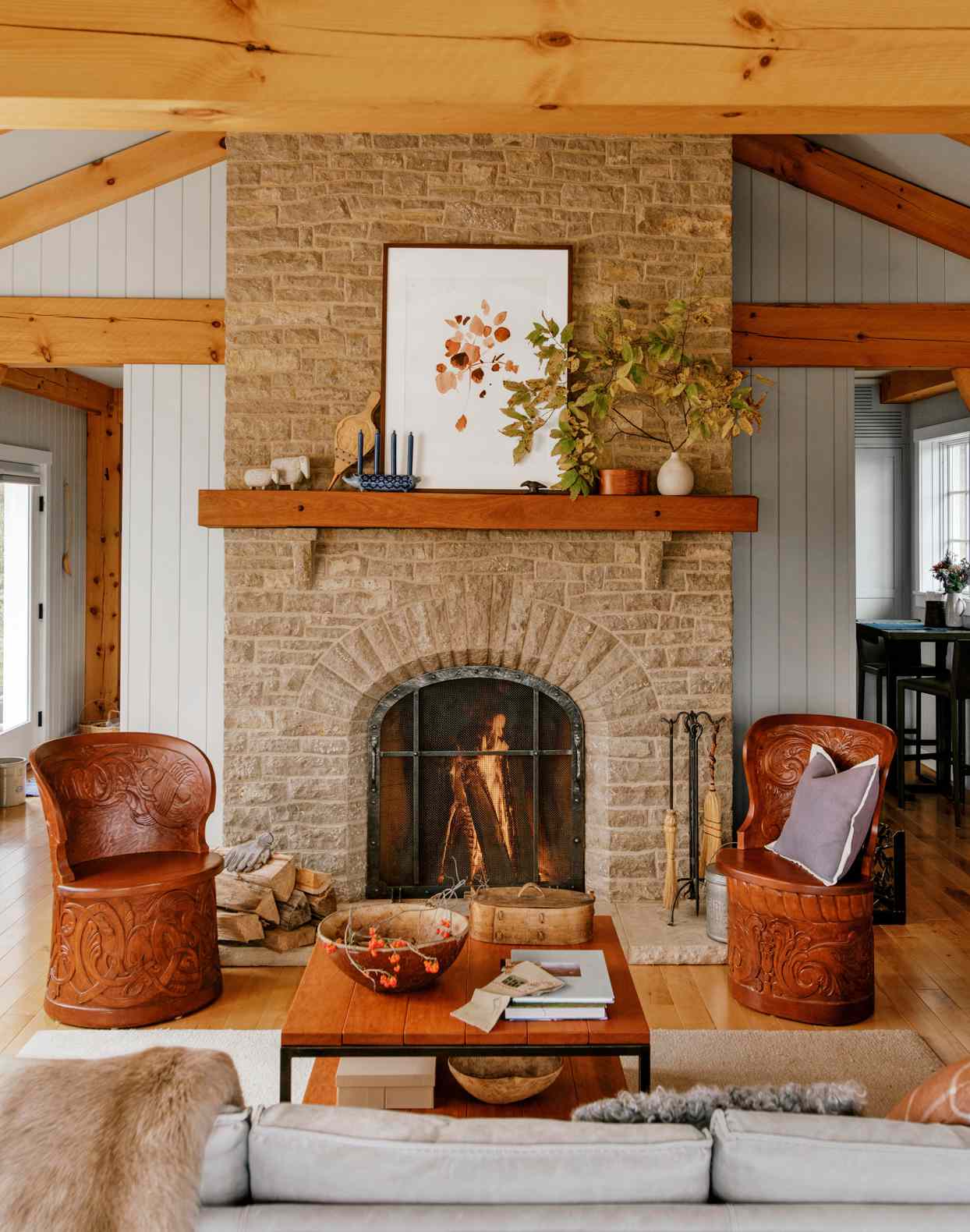 stone fireplace living room with carved wooden chairs