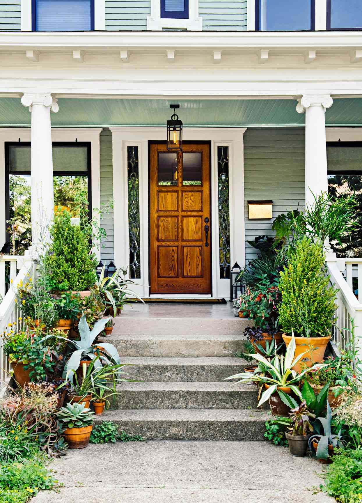 plant filled front porch wooden door