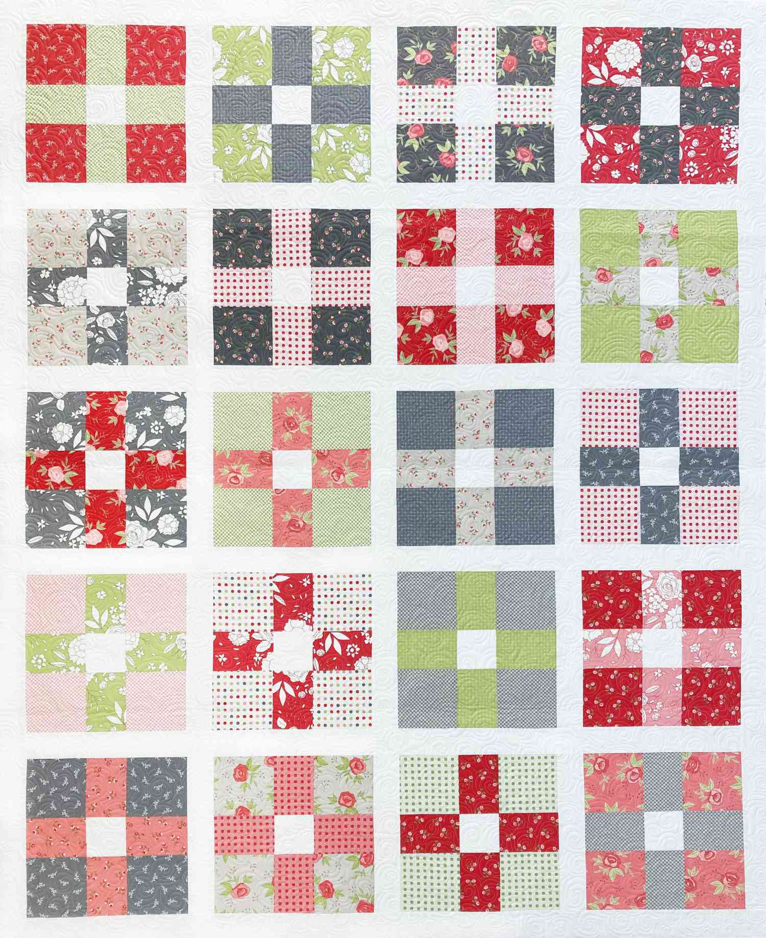 Plus sign quilt in gray, green, red, and pink fabric.