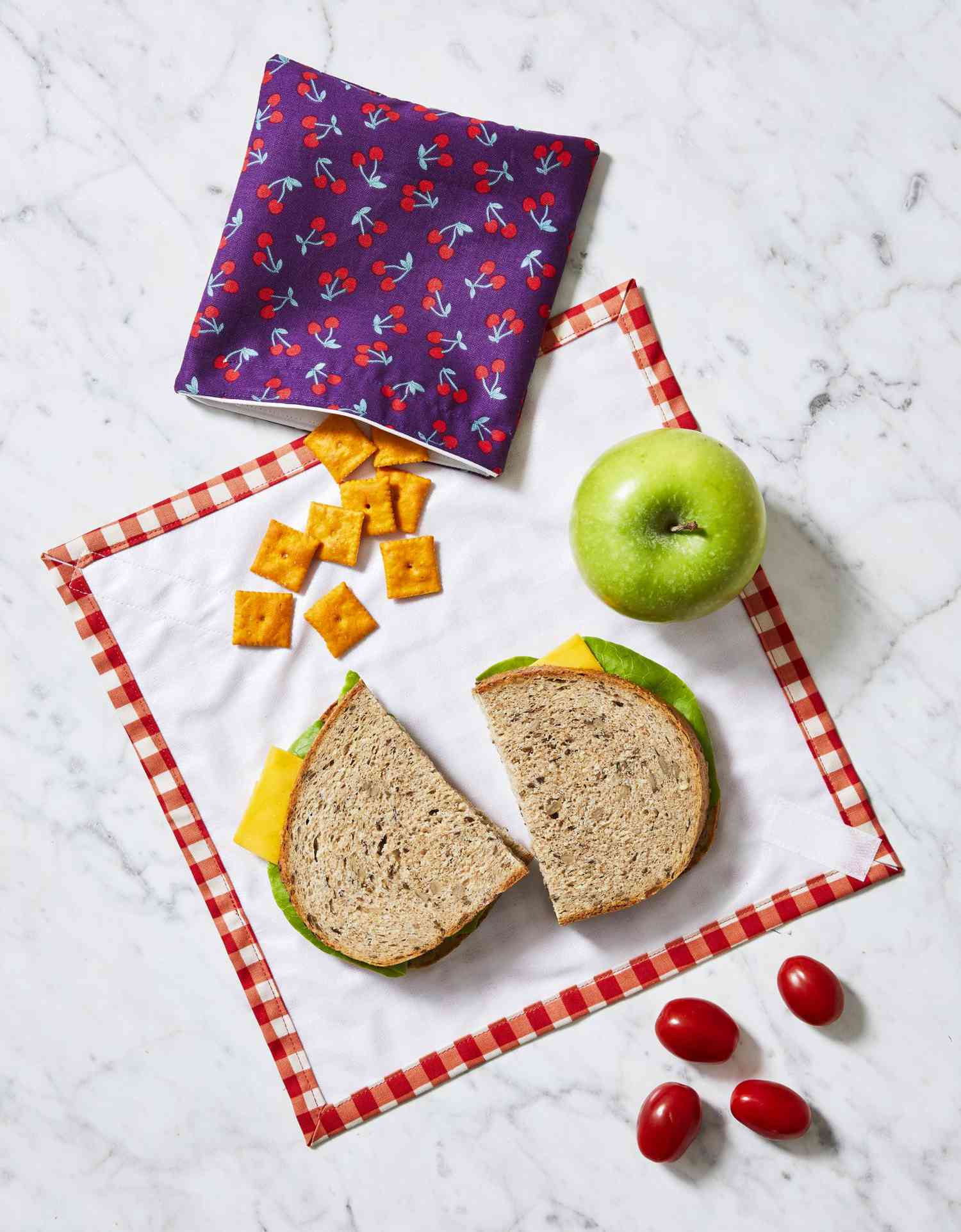 Fabric snack bag and sandwich wrap open with a sandwich on it