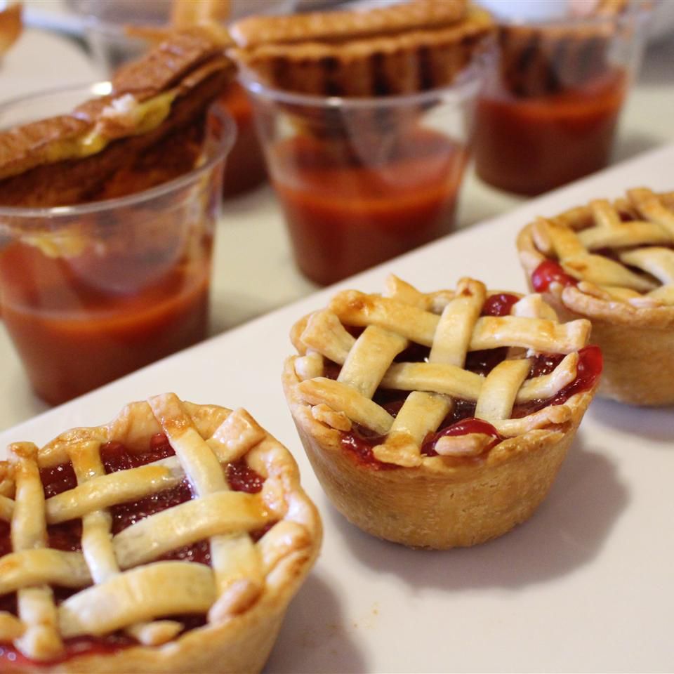 three mini lattice-topped cherry pies on a white tray