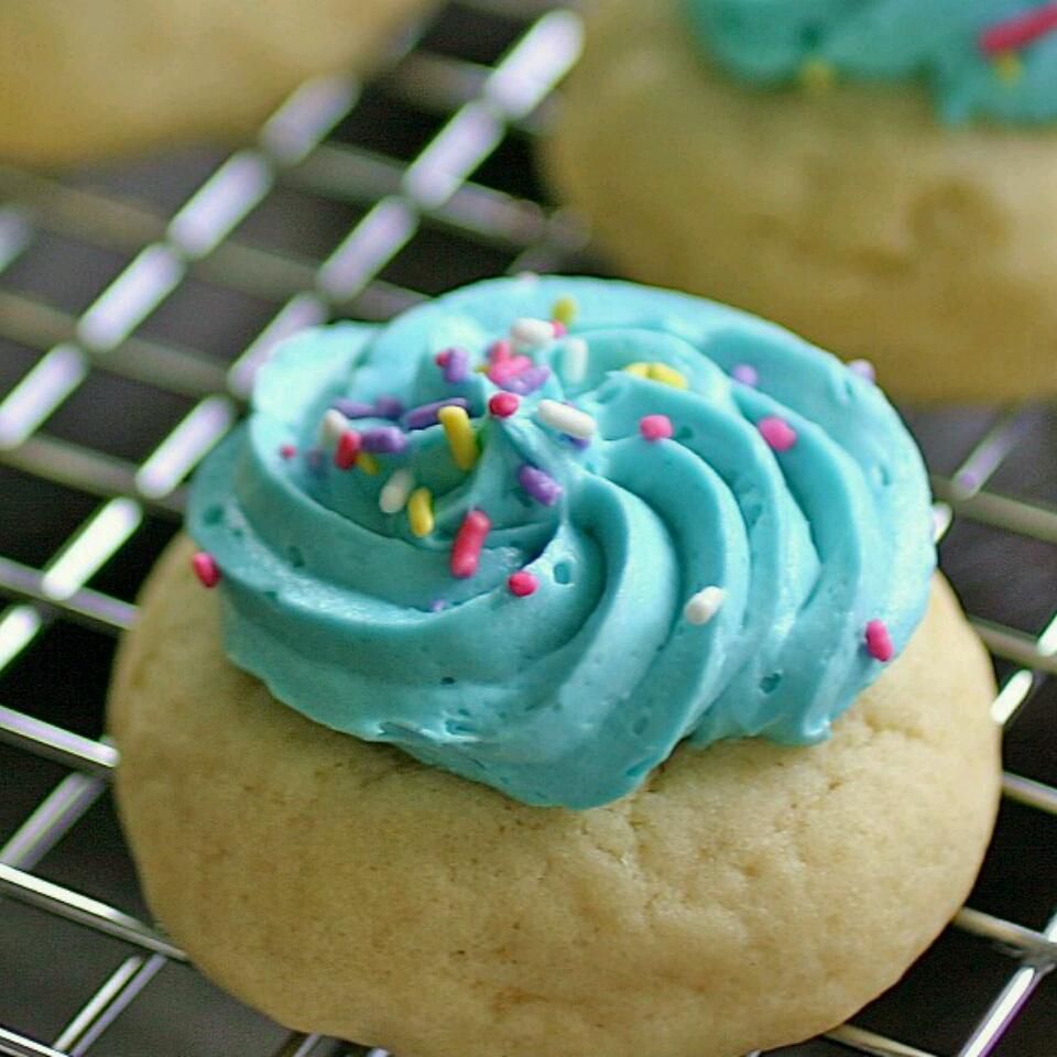 a round sugar cookie topped with a piped swirl of frosting and colored sprinkles