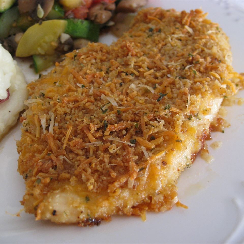 a breaded baked chicken breast with shredded Cheddar and Parmesan cheeses
