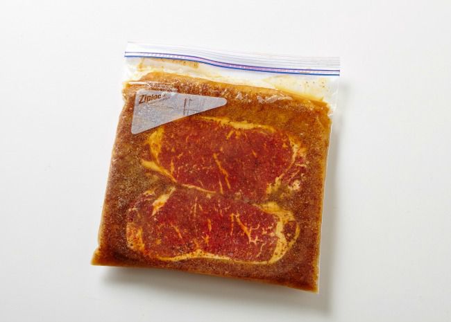 steaks marinading in plastic bag