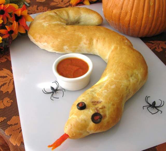 a long "snake" of calzone down with black olive ring eyes and red pepper tongue