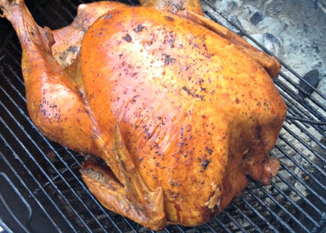 a beautifully bronzed whole turkey on a grill