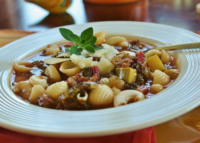 A full bowl of minestrone with mini shell pasta