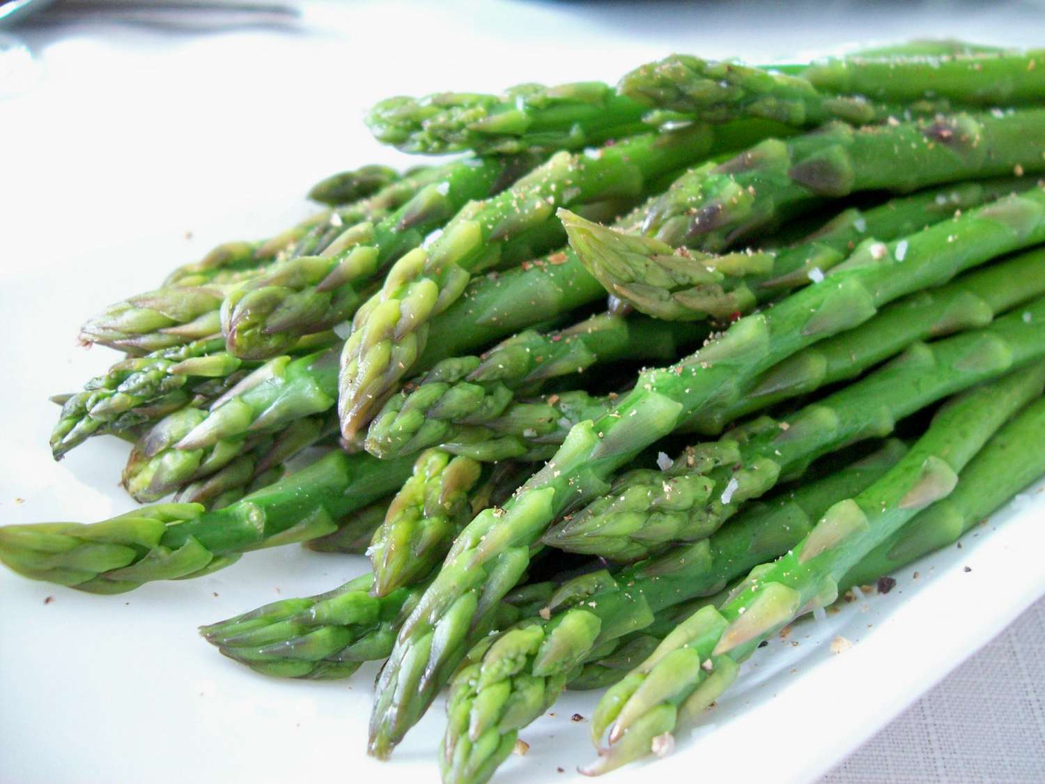 bright green asparagus spears on a white plate