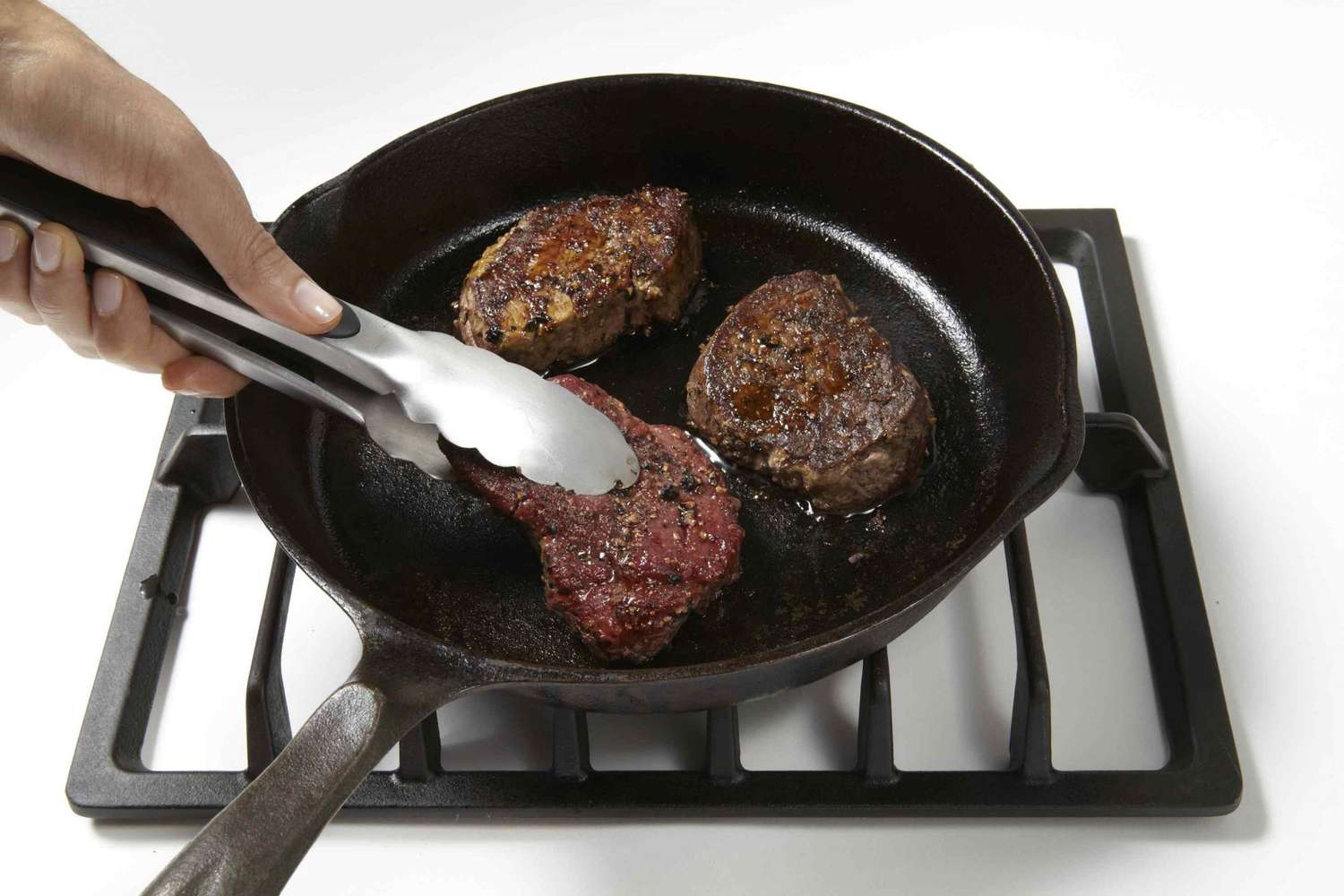 Steak grilling in cast iron skillet