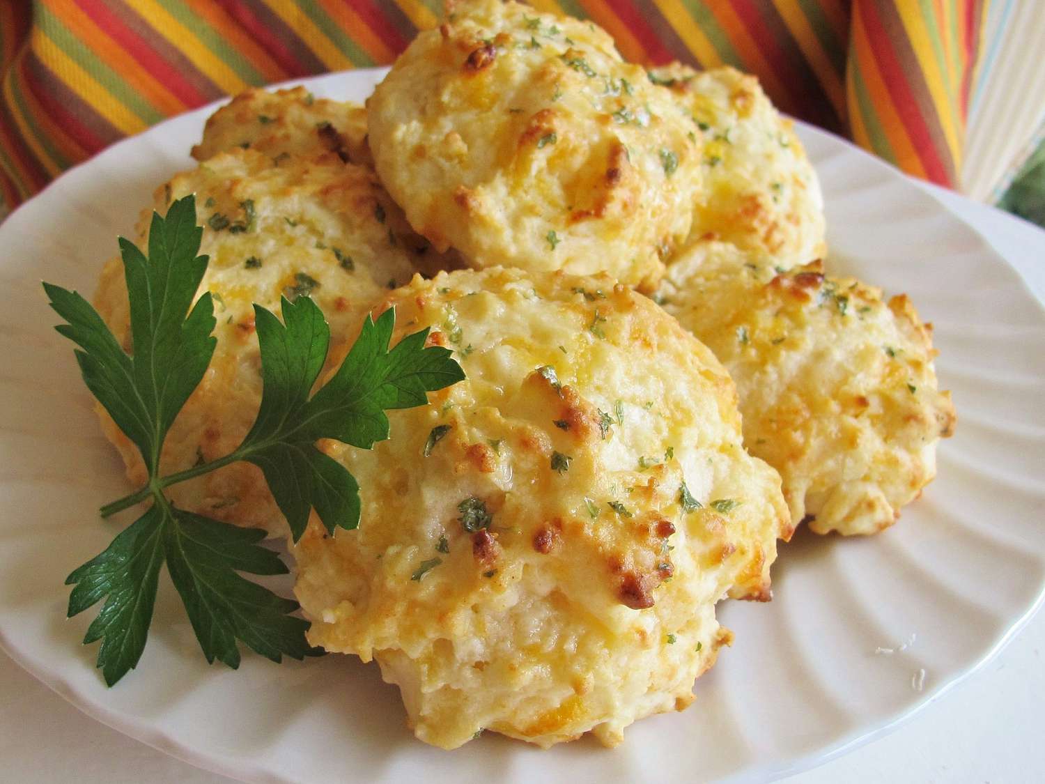 drop biscuits on a white plate garnished with a parsley sprig