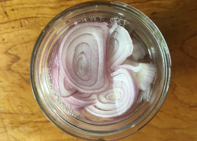 top-down view of shallot slices in a jar
