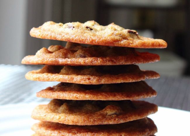 side view of a stack of thin, crispy-looking chocolate chip cookies