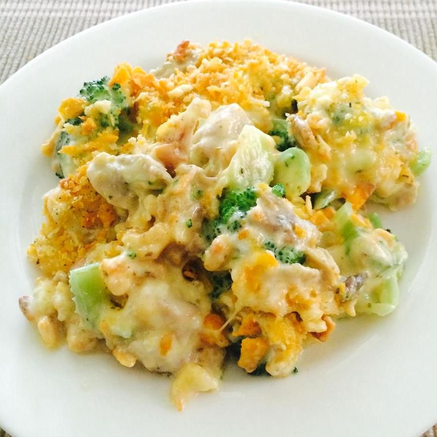 A serving of casserole with chicken, cheddar, and broccoli on a white plate