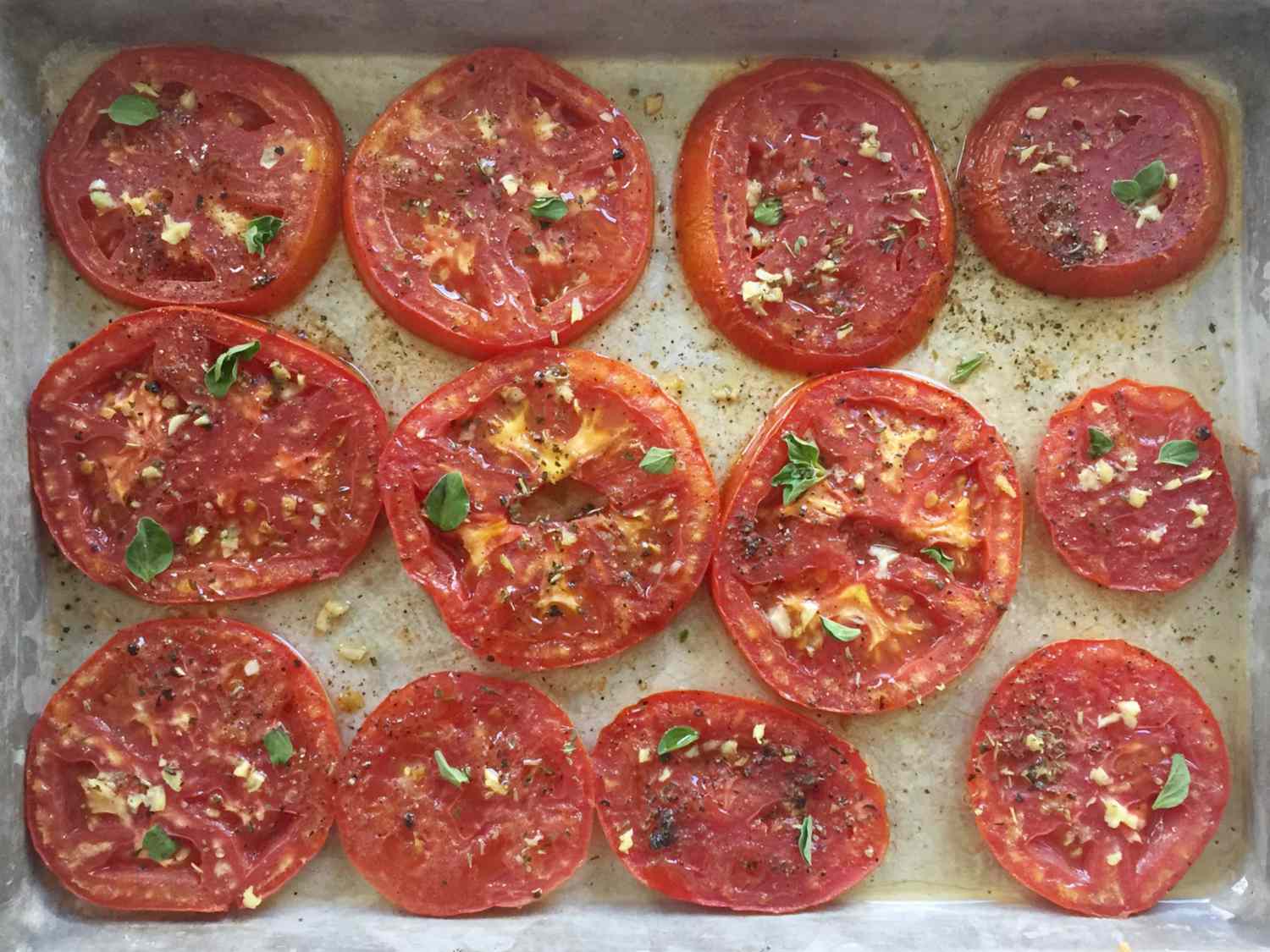 Baked tomato slices on a sheet tray.