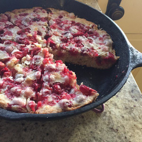 a crust-less pie dotted with cranberries baked in a cast iron skillet