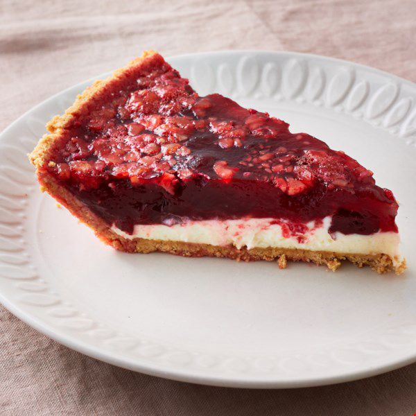 a slice of pie with a graham cracker crust, cream cheese layer, and Jell-O and cranberry sauce top layer