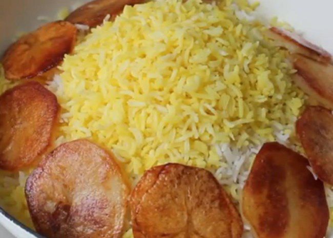 saffron-colored rice surrounded by rounds of fried potato