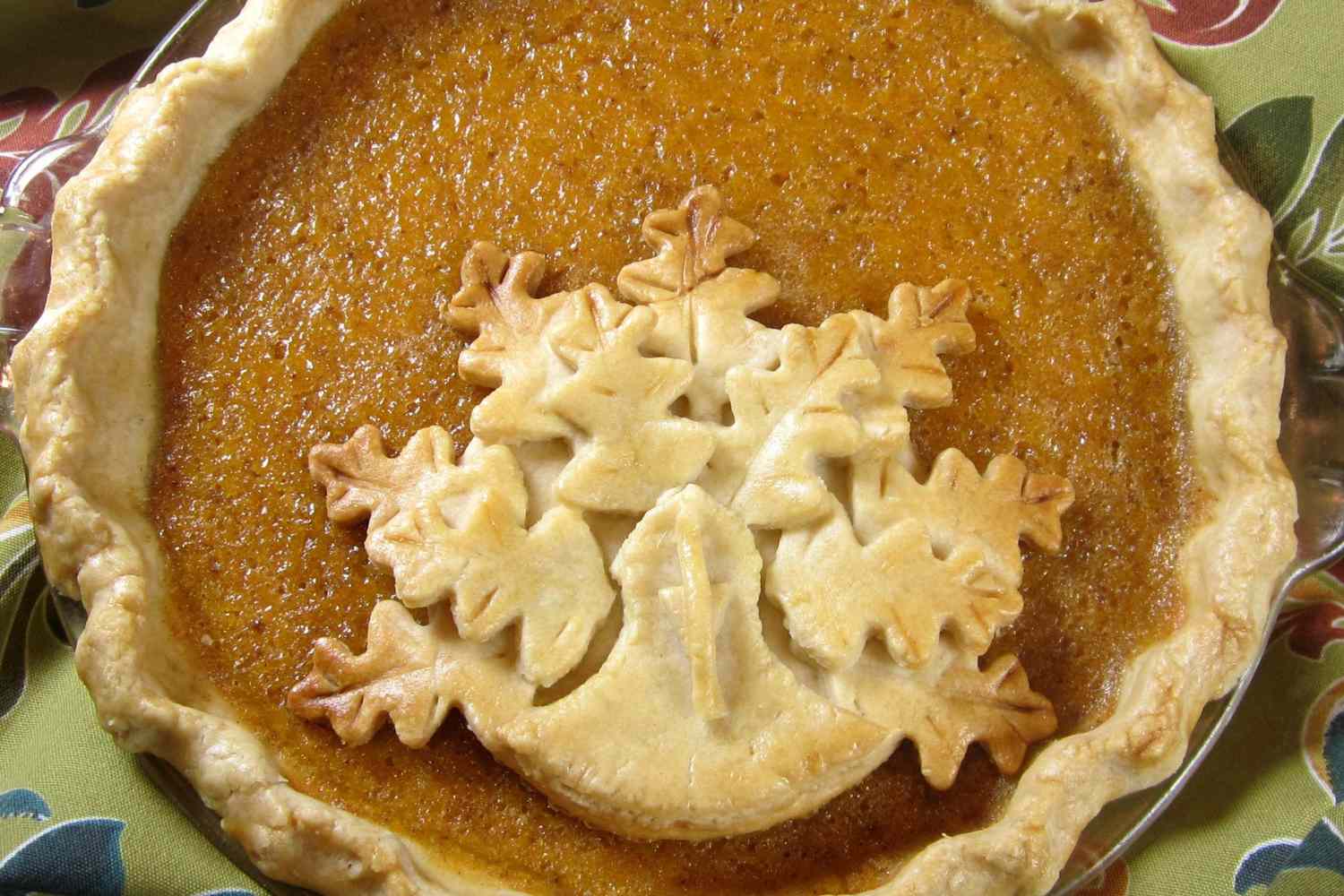 closeup of a smooth brown custard pie decorated with a turkey-shaped pastry cutout