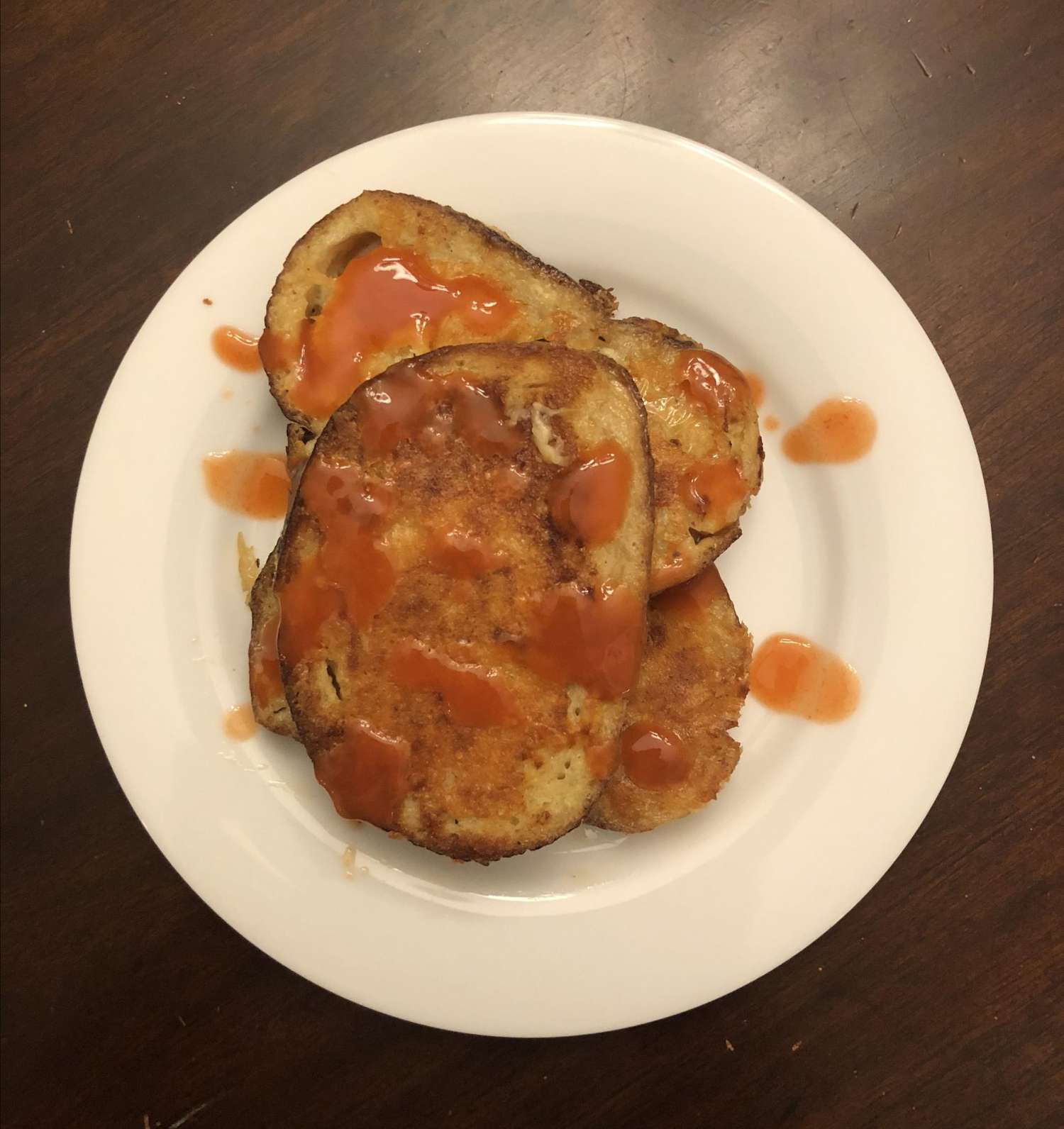french toast with buffalo sauce on a white plate