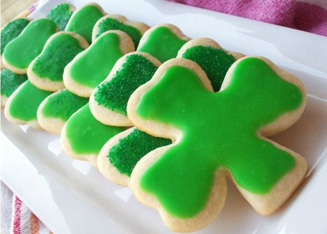 Shamrock-shaped sugar cookies frosted with green icing and green sugar for St. Patrick's Day