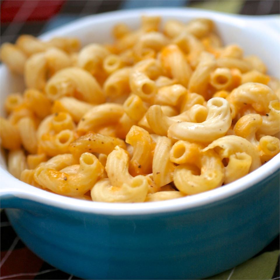 A round blue baking dish filled with mac and cheese