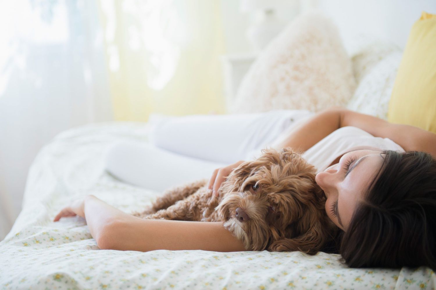 woman sleeping with dog in bed