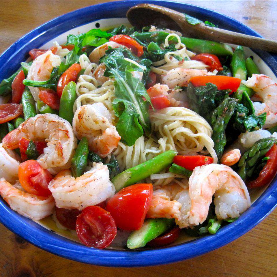 pasta primavera with shrimp in a white and blue bowl